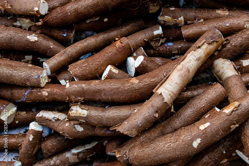 Large amount of unpeeled cassava being sold at a street fair. Top view.