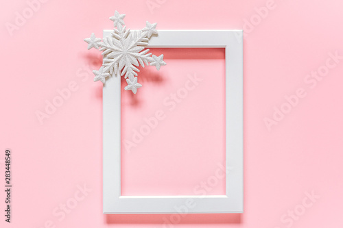 White frame with decoration snowflake on pink background with copy space. Concept Merry christmas or Happy new year. Minimal style Top view Flat lay Template for your design, card, invitation