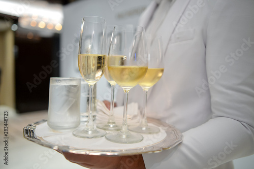 Waiter holding a tray with glasses of wine at party