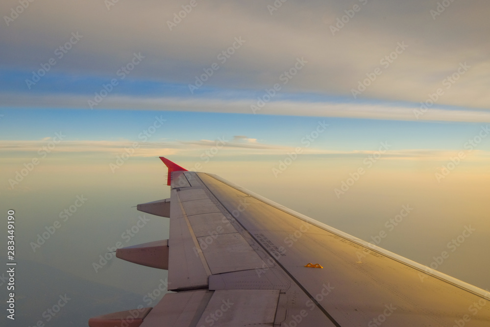 Flying and traveling, view from airplane window on the wing on sunset time Flying and traveling, view from airplane window on the wing on sunset time