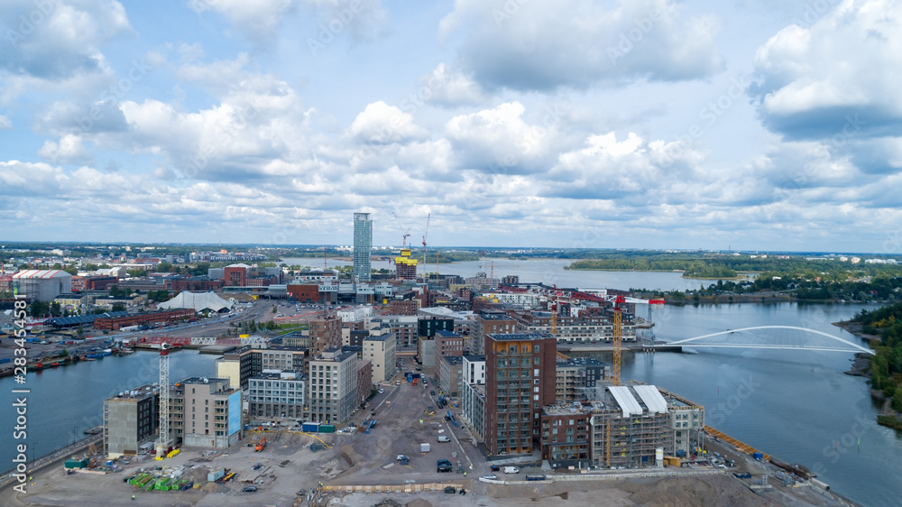 New modern buildings under construction in Helsinki. Sompasaari at summer day. Aerial view of beautiful bridge.