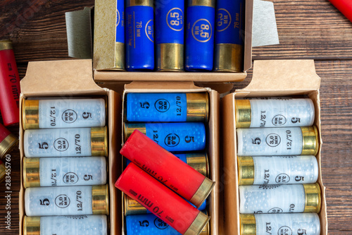 12 gauge caliber color cartridges hunting shells in a box pack on a brown wooden background