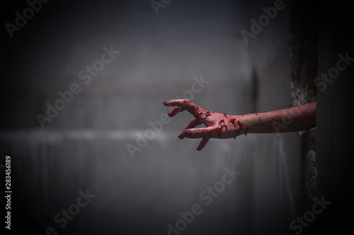 Nightmares of scary fear at the halloween festival. Close up bloody hands protruding from the wall, Horror and terror.