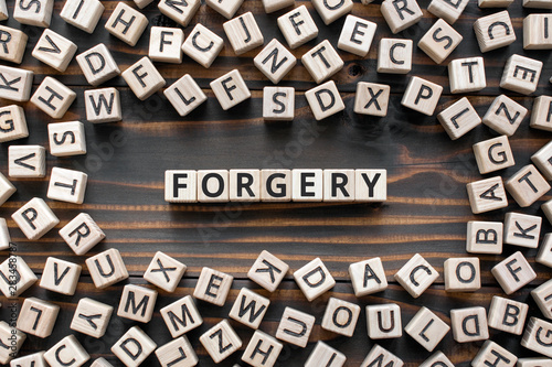 Forgery - word from wooden blocks with letters, illegally copying or fake  crime concept, random letters around, top view on wooden background