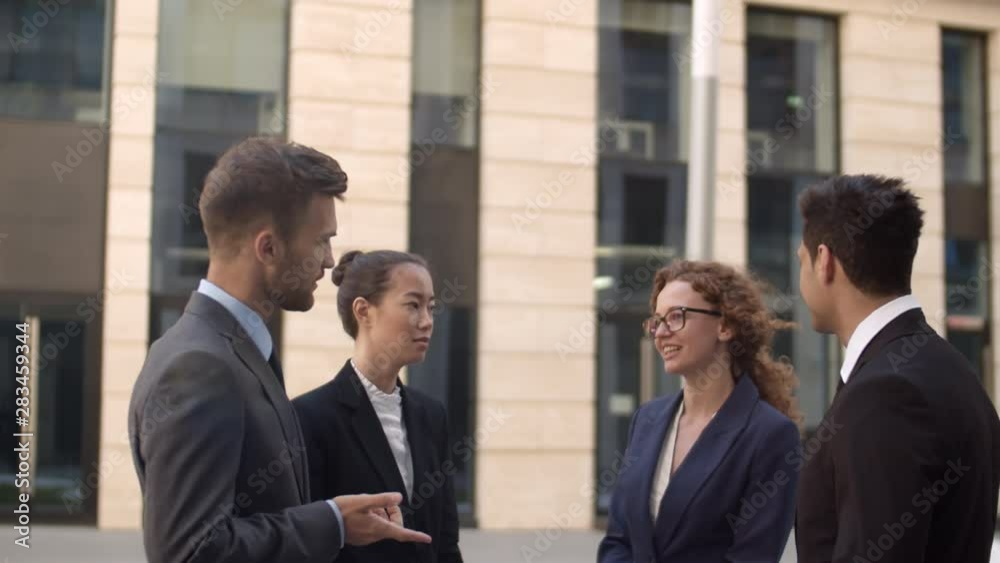 Lockdown of four multiethnic business people standing outdoors and having talk