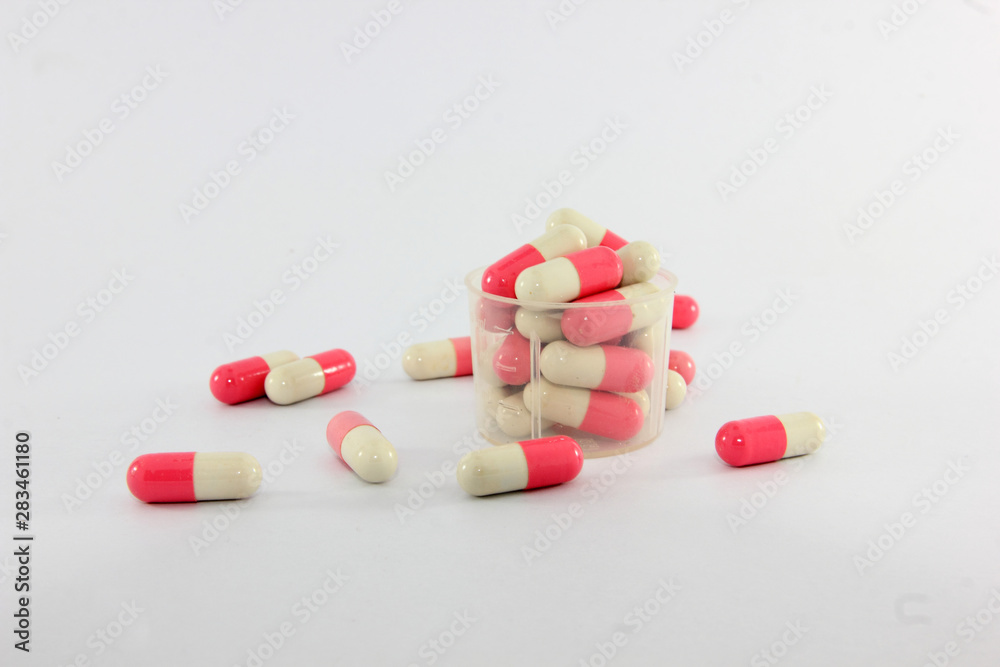 Pink and white capsules on white background. Antimicrobial capsule pills, Pharmacy. Pink and white capsules on white background. Antimicrobial capsule pills, Pharmacy.