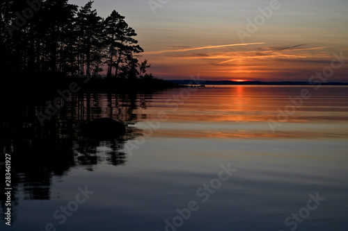 orange sunset over a calm lake in Sweden © Jonas