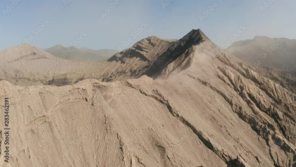Cinematic drone shot aerial view of Mount Bromo crater edge with active volcano smoke in East Java, Indonesia Cinematic drone shot aerial view of Mount Bromo crater edge with active volcano smoke in East Java, Indonesia