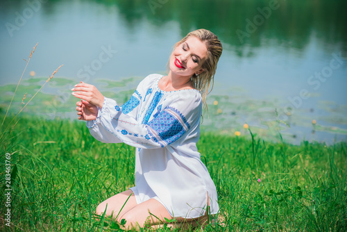 Concept of ethnic fashion. Pretty nice girl in white embroidered shirt at nature location 