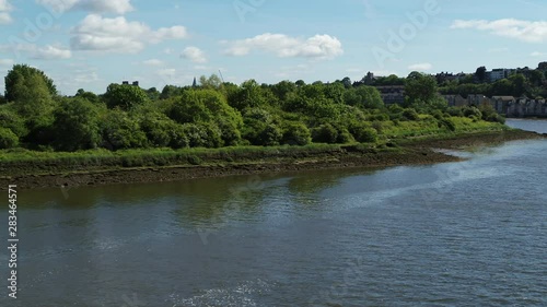 Aerial push over reveal from the River Medway over the river bank to reveal Rochester Castle, Cathedral & Town. photo