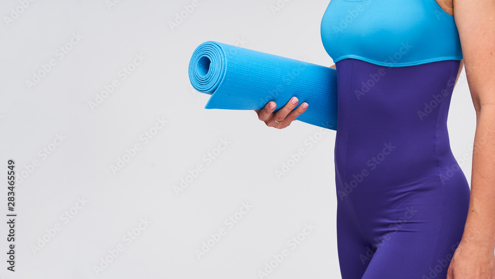 young athletic woman with a Mat for gymnastics in her hands. young athletic woman with a Mat for gymnastics in her hands.
