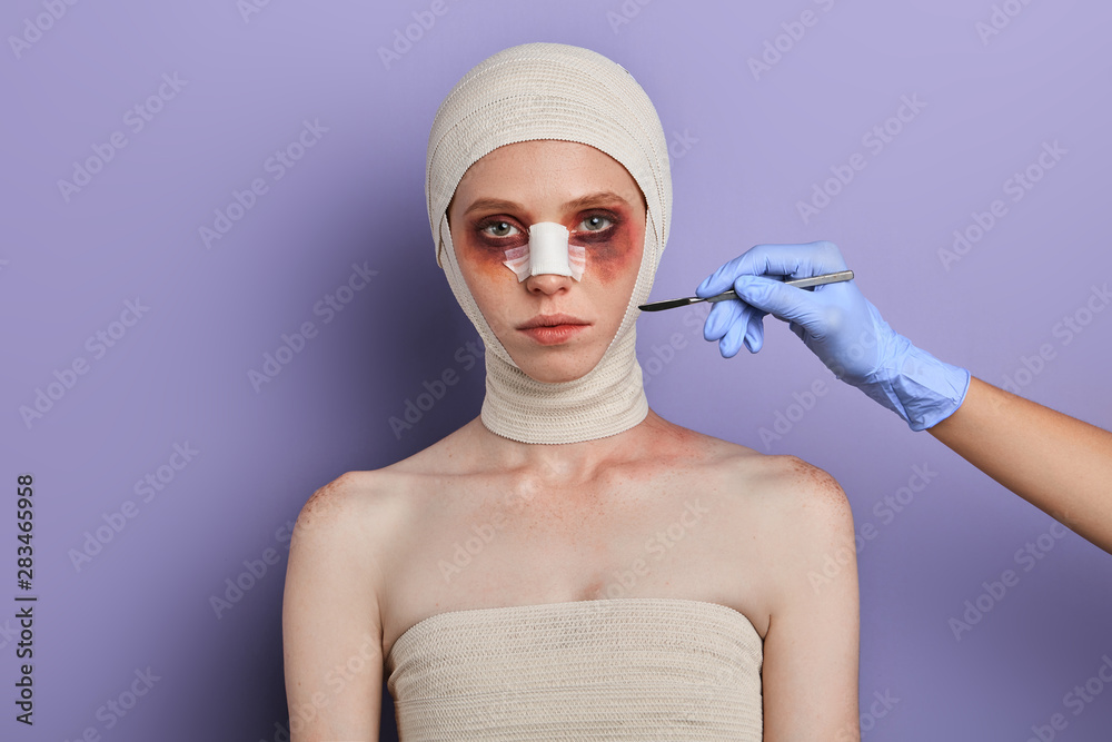 Doctors using scalpel during plastic surgery. close up portrait
