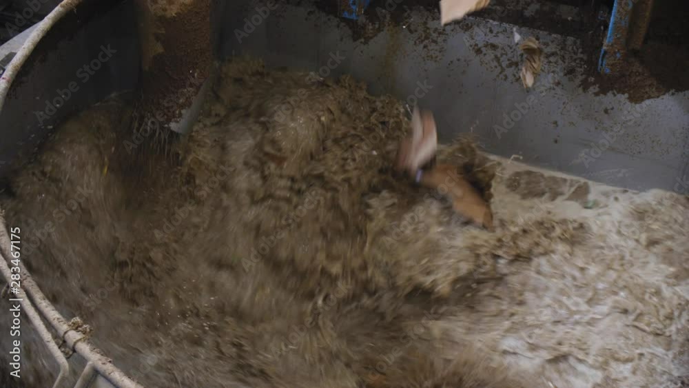 blocks of waste paper fall down into hot cellulose at plant
