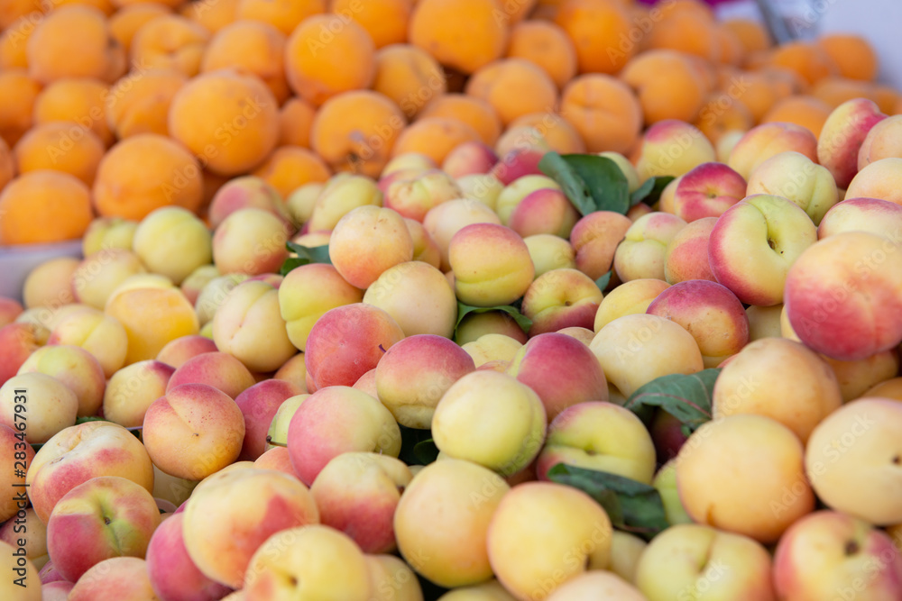 Fresh raw ripe juicy sweet apricots and peaches sold on outdoor market. Farm seasonal spanish fruits and vegetables Fresh raw ripe juicy sweet apricots and peaches sold on outdoor market. Farm seasonal spanish fruits and vegetables