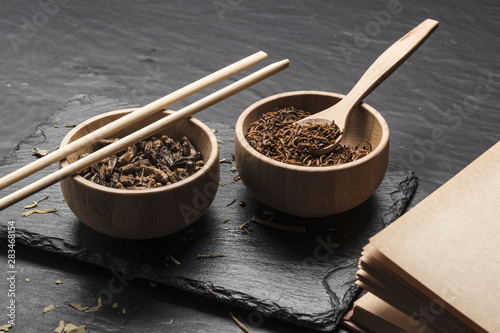 Wooden bowls with insects on slate board