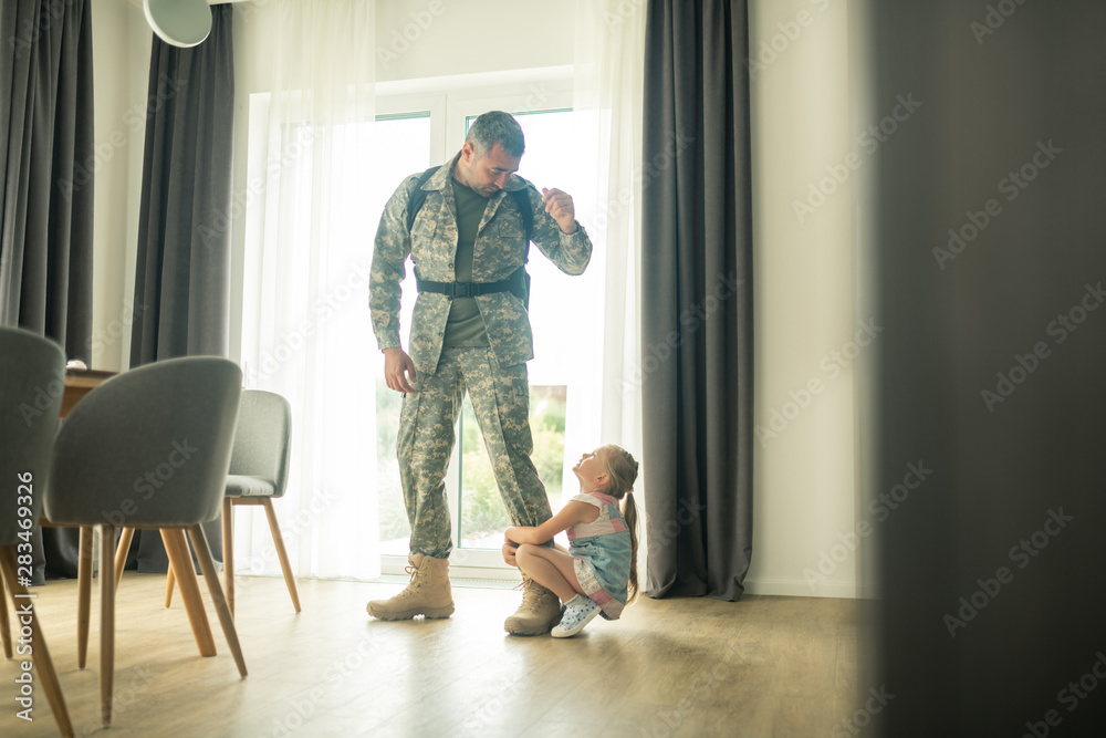 Serviceman calming his daughter down while coming back soon Serviceman calming his daughter down while coming back soon