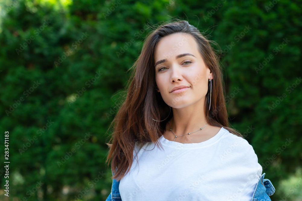 Portrait of beautiful young girl posing in summer park. Majestic woman's beauty. Youth, happiness, lifestyle.