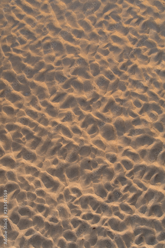 Obraz premium Footprints left in the sand of the beach by the waves when the tide is low.