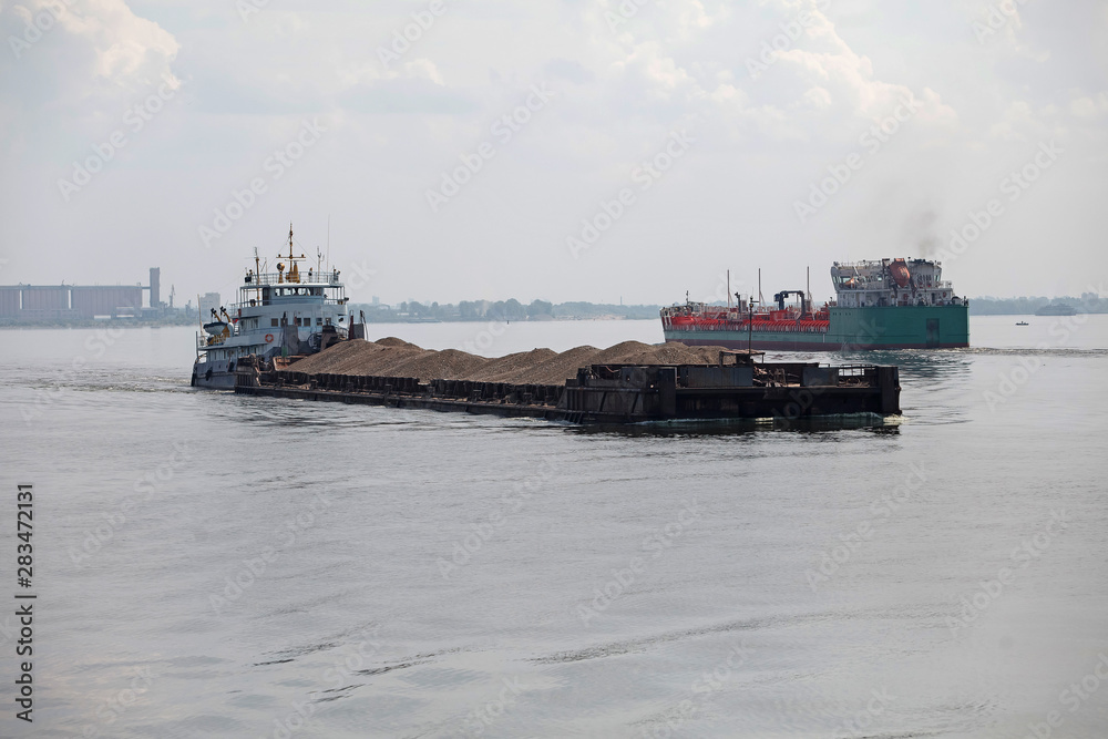 Barge pushed by tug boat on the river