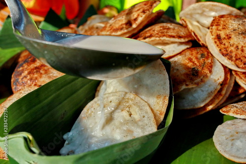 Serabi Kocor. Traditional Javanese dessert snack of pancake with coconut milk and palm sugar sauce. photo