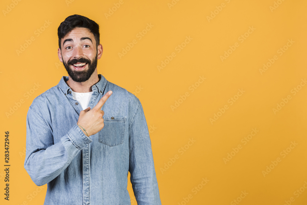 Medium shot happy guy pointing up Medium shot happy guy pointing up
