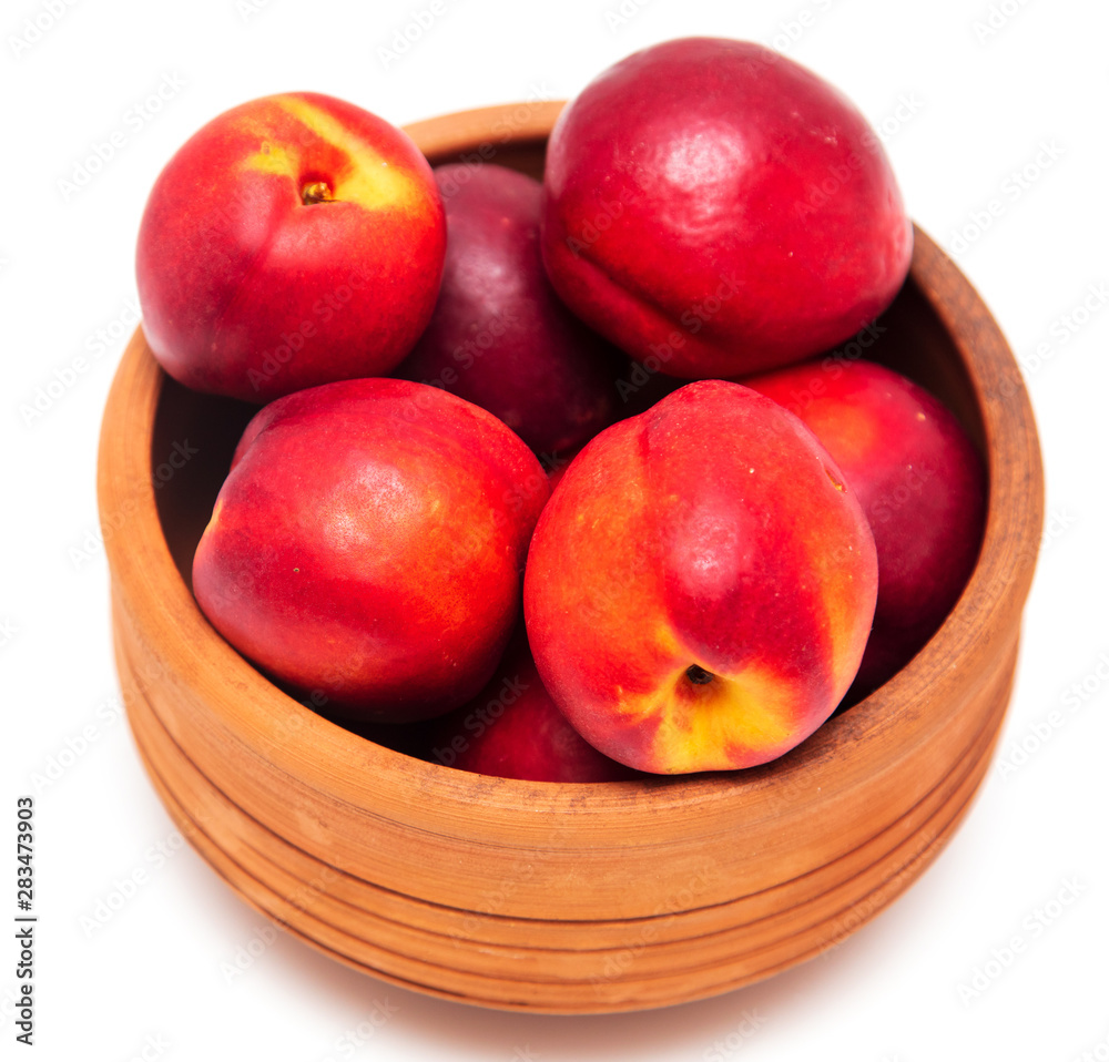 Ripe nectarine in clay pots on a white background Ripe nectarine in clay pots on a white background