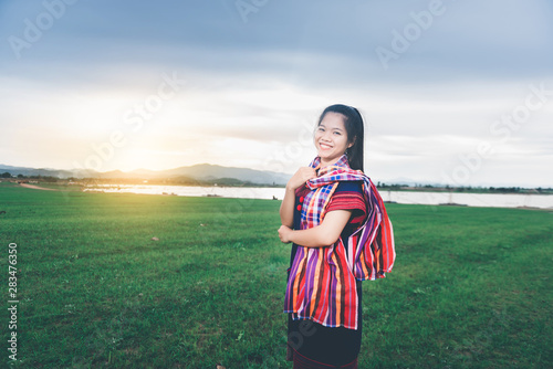 Portrait of beautiful Asian girl with local dress, standing in the mist of fieldt at countryside of Thailand photo