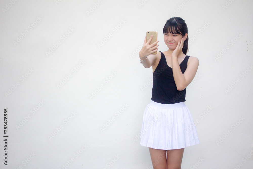 Portrait of thai adult beautiful girl black shirt white skirt using her smart phone Selfie Portrait of thai adult beautiful girl black shirt white skirt using her smart phone Selfie