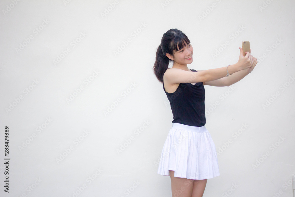 Portrait of thai adult beautiful girl black shirt white skirt using her smart phone Selfie Portrait of thai adult beautiful girl black shirt white skirt using her smart phone Selfie