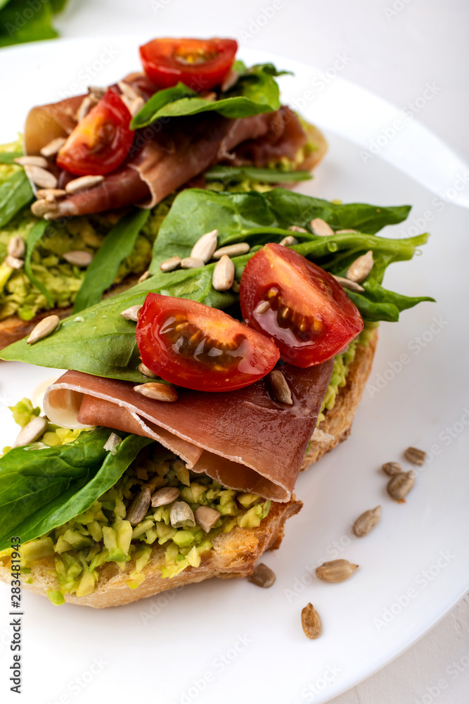 Sandwiches with avocado cream, tomatoes and jamon. Sandwiches with avocado cream, tomatoes and jamon.