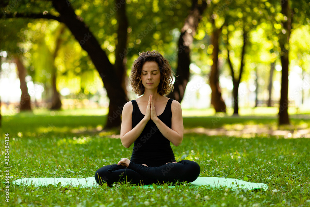 Woman practices yoga in morning in park in fresh air. Lotus pose. Woman practices yoga in morning in park in fresh air. Lotus pose.