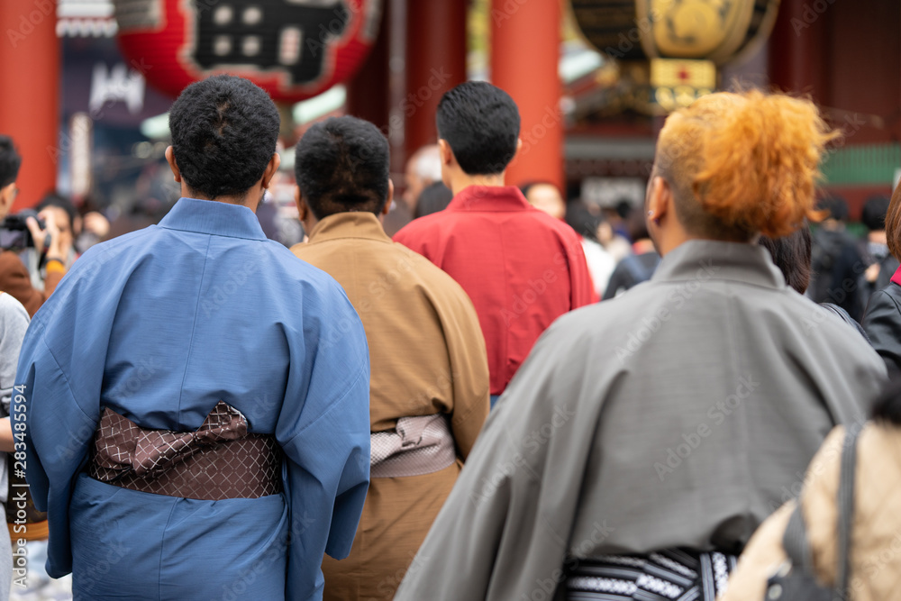 Fototapeta premium Młoda dziewczyna ubrana w japońskie kimono stoi przed świątynią Sensoji w Tokio, Japonia. Kimono to tradycyjny japoński strój. Słowo „kimono”, które w rzeczywistości oznacza „rzecz do noszenia”