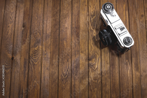 Retro camera on wooden boards background