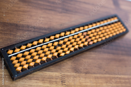 Close up abacus over wooden background.