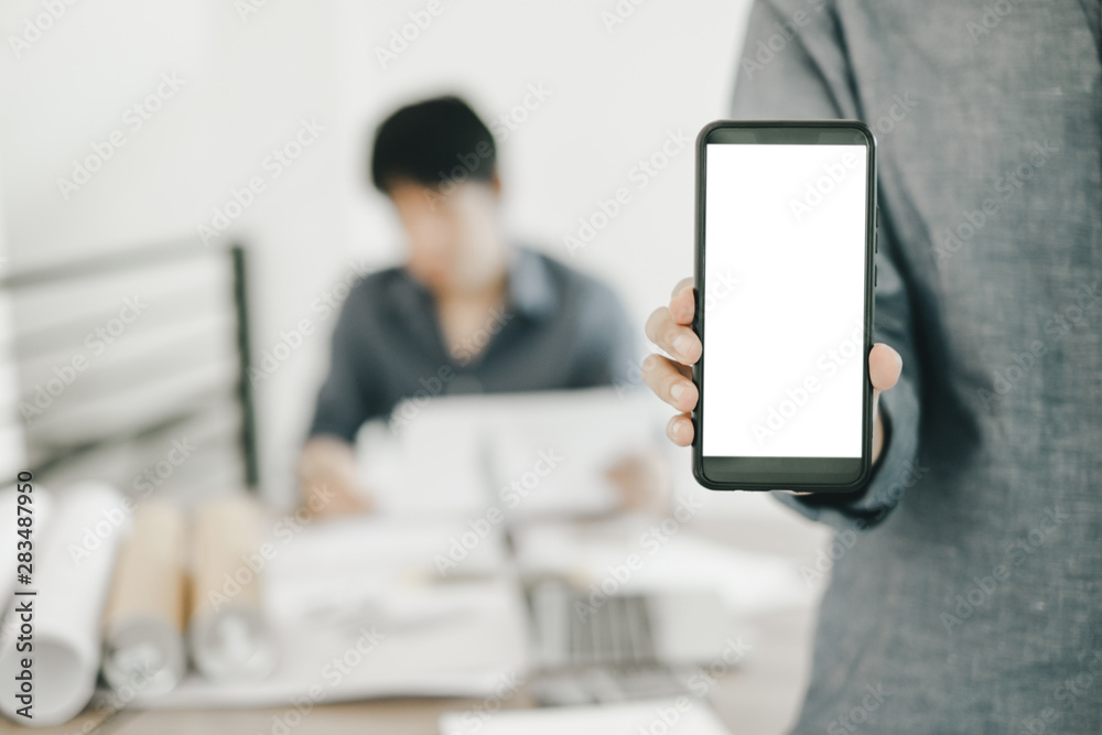 Mockup image of engineers showing smartphone design building Project in office, mockup concept