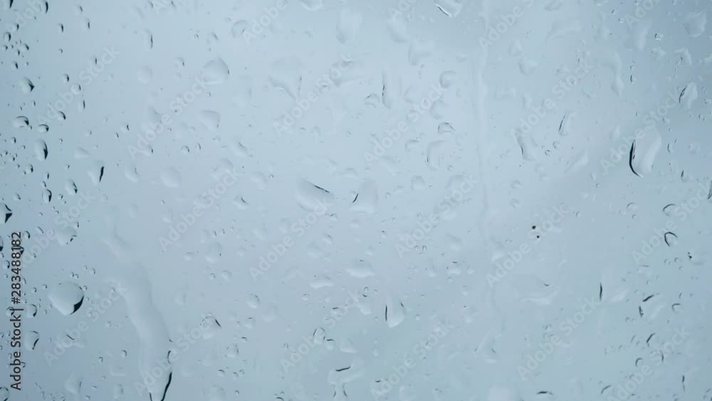 Close-up of water droplets on glass, rain on glass of window, Slow motion Close-up of water droplets on glass, rain on glass of window, Slow motion