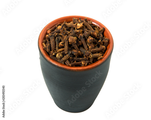 Dry cloves in a bowl isolated on white background. Spice on isolate. View from above.