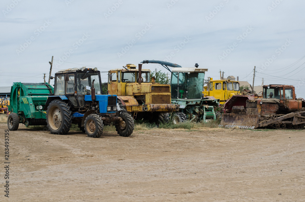 agricultural machinery such as tractor, plow, harrow stands in the field