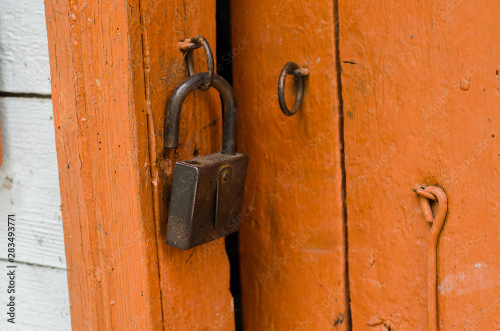 old lock hanging on a wooden painted door