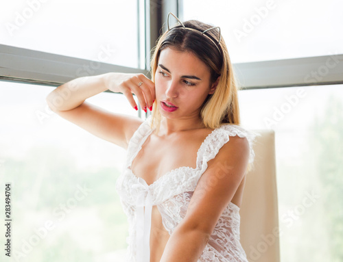 Beautiful young woman posing near window wearing lingerie Free Download Beautiful young woman posing near window wearing lingerie - GFXLoad