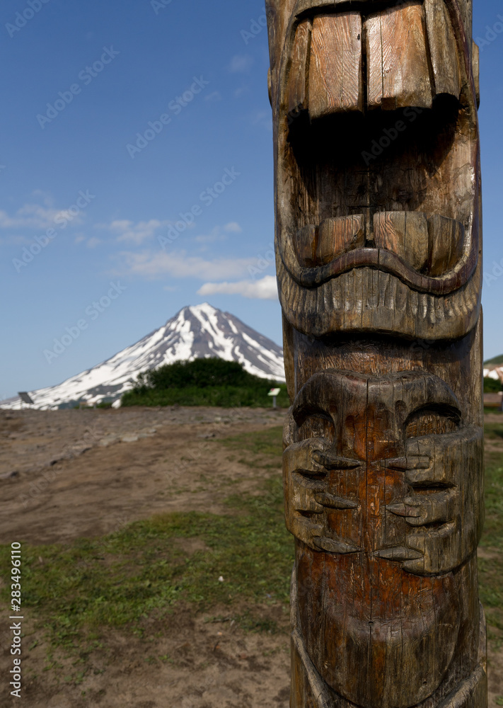 Detail of a wooden Gamul on Vilyuchinsky pass. Vilyuchik volcano in the background. Kamchatka Peninsula, Russia. Gamuls are mountain spirits, living on the hills, which produce rain and lightning. Detail of a wooden Gamul on Vilyuchinsky pass. Vilyuchik volcano in the background. Kamchatka Peninsula, Russia. Gamuls are mountain spirits, living on the hills, which produce rain and lightning.
