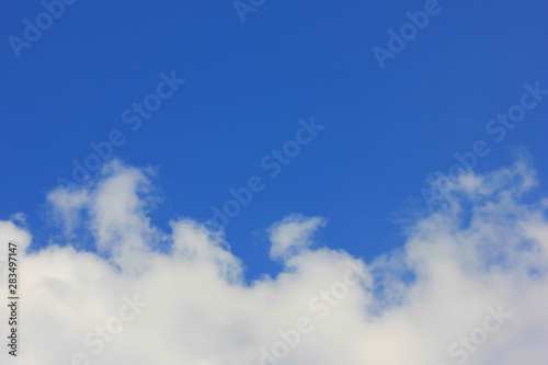 Blue sky with clouds banner. Cloudscape background with clear blue tone on top, and fluffy white clouds on the bottom 