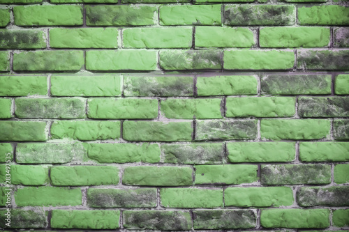 Background of the brick wall is green. Wasting away the background of vintage brick walls. Texture of worn and dirty brickwork.