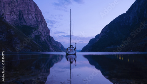 sailboat in Lyse fjord with calm water at dusk, Norway photo