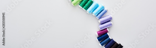 panoramic shot of bright and colorful threads on white background photo