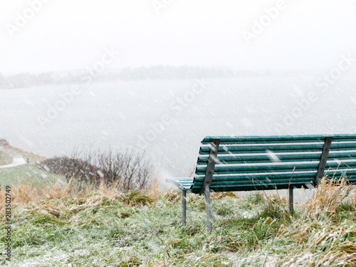 blurry and out-of-focus landscape with snowfall, fog and blurred outline, blurred background