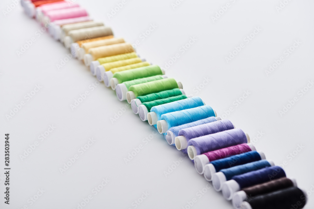 selective focus of bright and colorful threads on white background selective focus of bright and colorful threads on white background