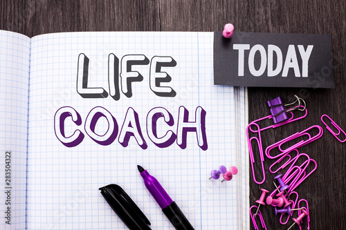 Handwriting text Life Coach. Concept meaning Mentoring Guiding Career Guidance Encourage Trainer Mentor written Notebook Book wooden background Today with Thumbpin Marker Paper Clip. photo