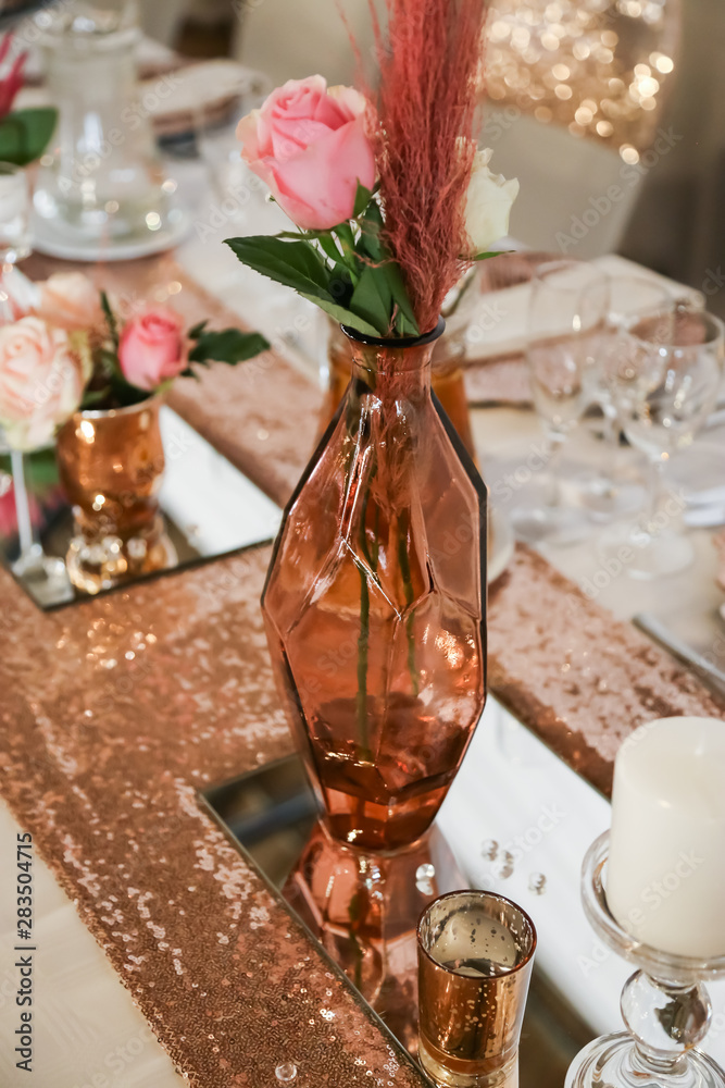 table setting in rose gold with candles and fresh flowers