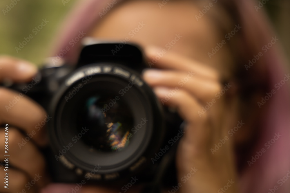 unfocused blurred concept female portrait of incognito photographer with black digital camera unfocused blurred concept female portrait of incognito photographer with black digital camera
